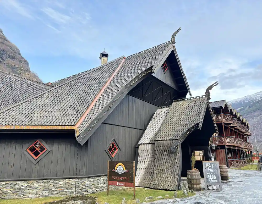 A dark timber hall with carved dragon heads on the gables