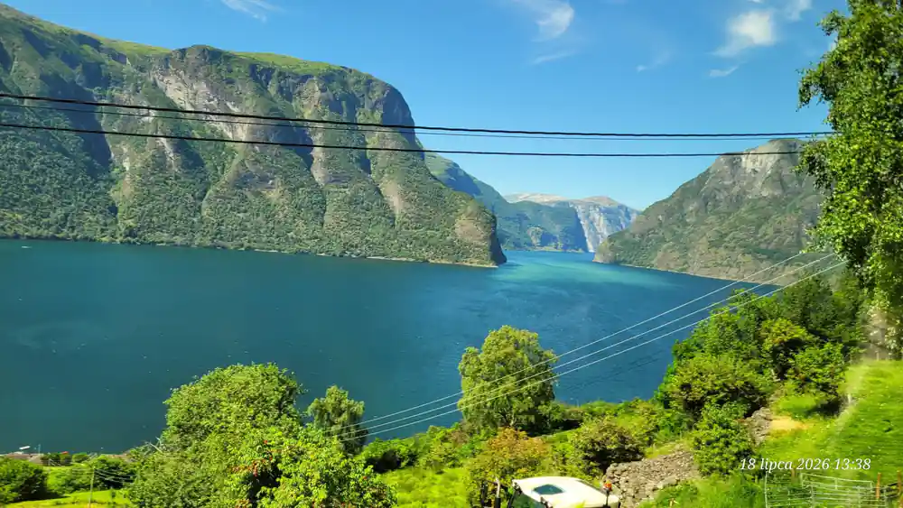 The fjord seen from the boat with a green headland ahead