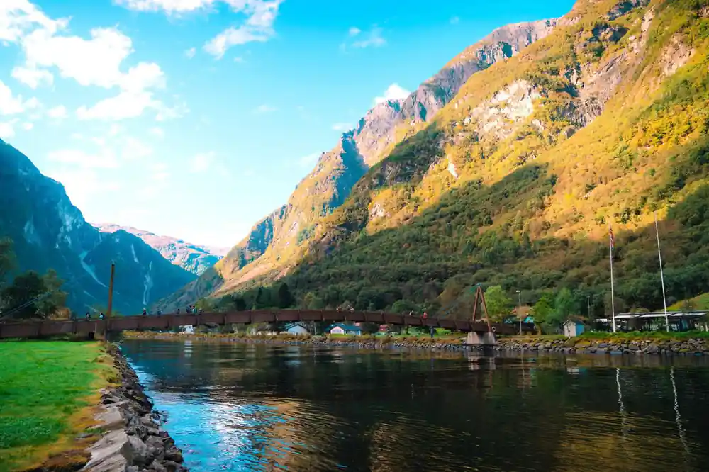 An old stone bridge and a village at the head of a green fjord