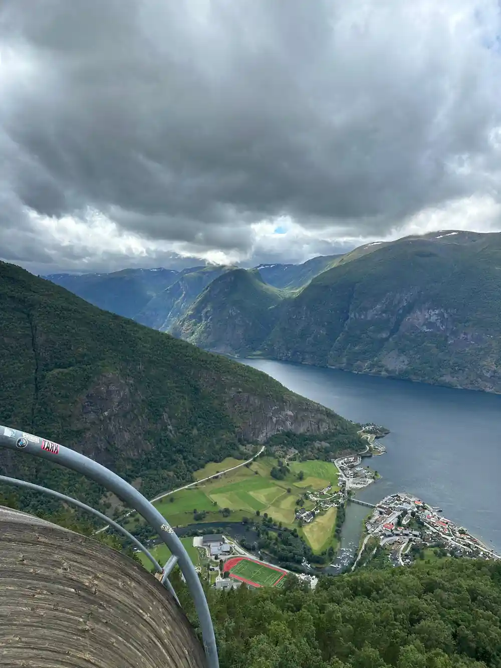 The valley floor and village seen from the mountain road under heavy cloud