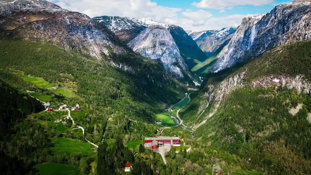 The valley and its red farms seen from far above with snow on the tops