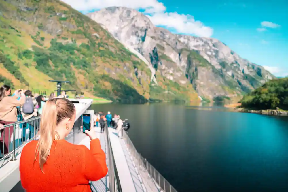 A visitor photographing the fjord from the timber platform