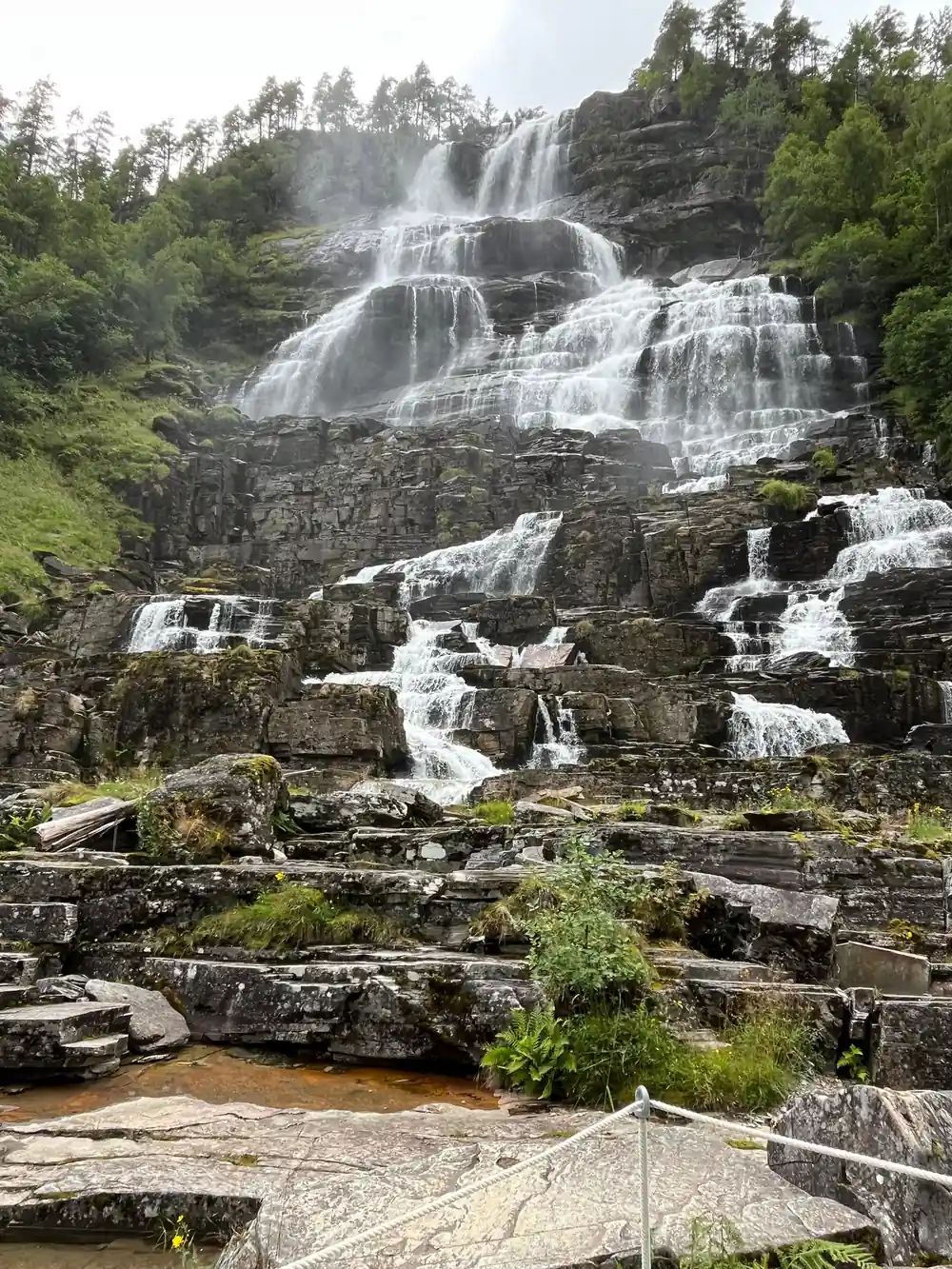 Water spreading over bare rock ledges at the foot of the falls